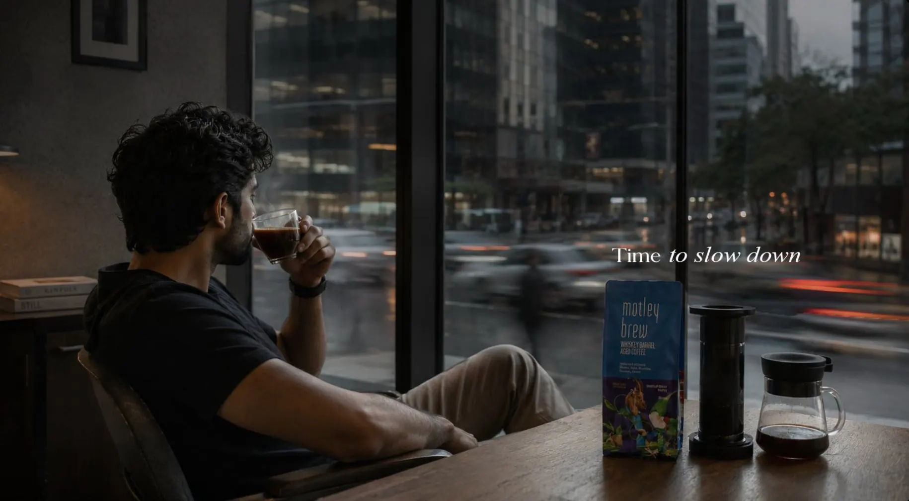 Time to Slow Down: a man drinking coffee by a city window